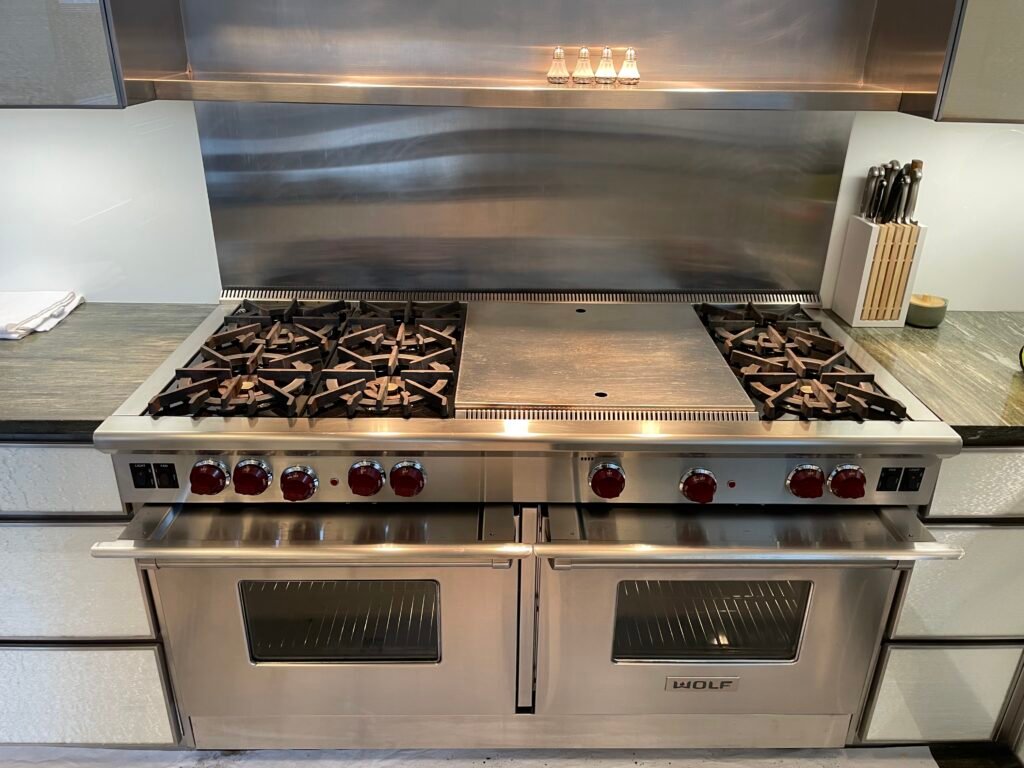 Wolf range featuring six burners, flat top, and grill, gleaming finish after meticulous detail cleaning service