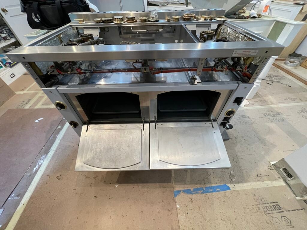 La Cornue Château range disassembled for deep cleaning, premium French appliance craftsmanship