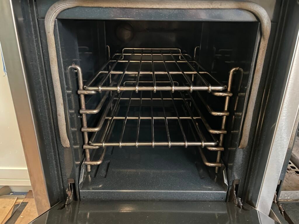Side‑by‑side comparison of a Wolf cooking range in NYC before and after OvenPal’s professional deep cleaning, showing significant build up of grease, grime, and residue that was completely removed from the range's cavity and stainless steel racks