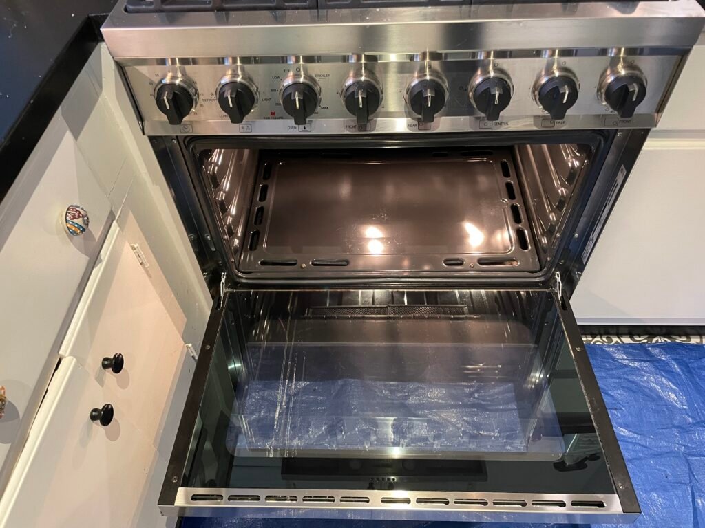 Thermador range detail cleaned with open door, sparkling glass, knobs, and pristine oven cavity