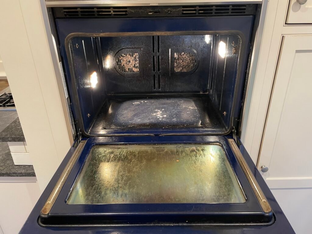 Grease‑covered interior of a Wolf built‑in electric oven before professional deep cleaning and detailing.