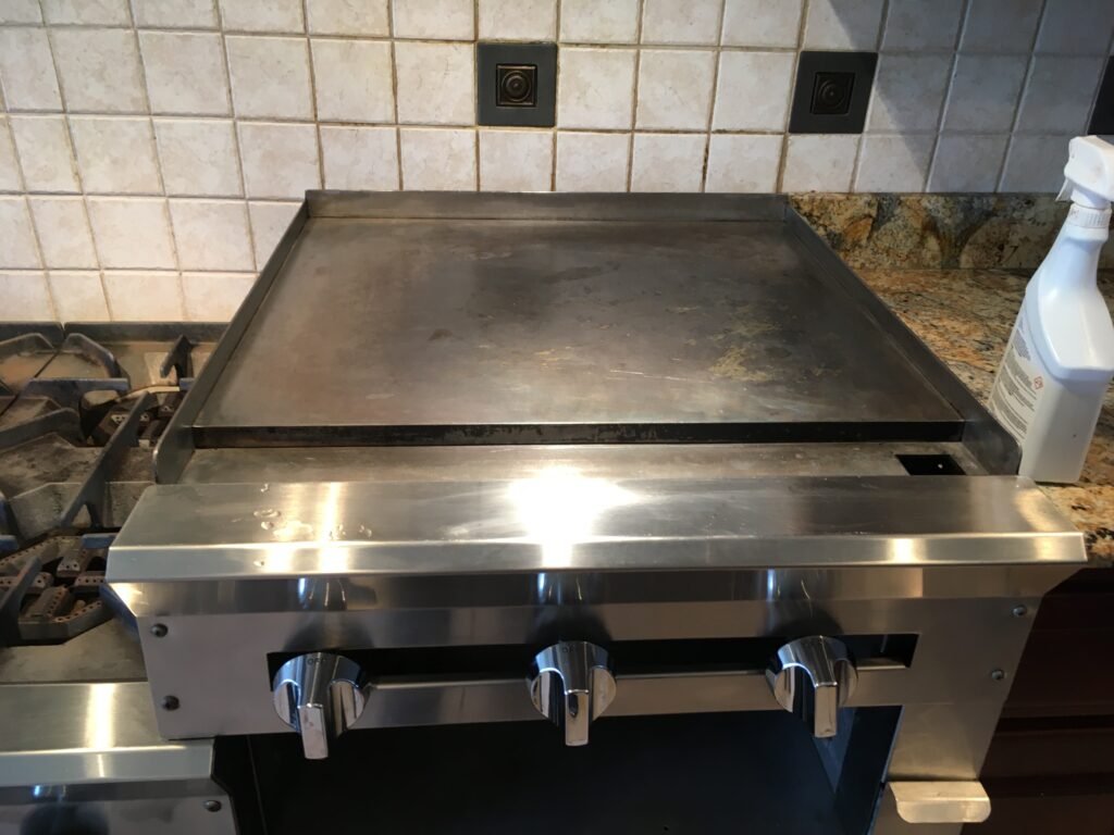 Side‑by‑side comparison of a Vulcan Professional Cooking Range Griddle after professional deep cleaning by OvenPal, showcasing grease, grime, and residue removal.