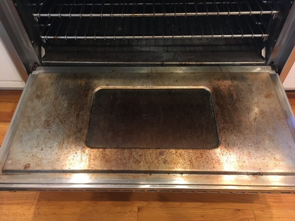 Side‑by‑side comparison of a Kenmore Cooking Range Door before and professional deep cleaning by OvenPal, showing buildup of grease, grime, and residue.