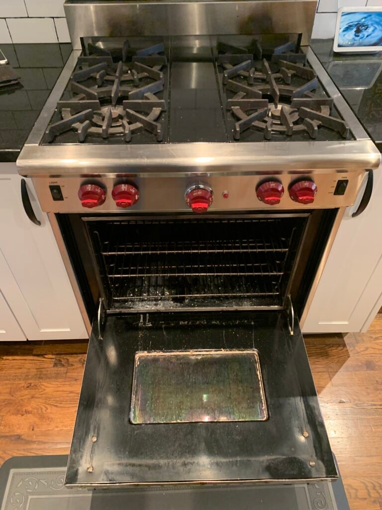Grease‑covered Wolf gas range before professional deep cleaning and detailing service.