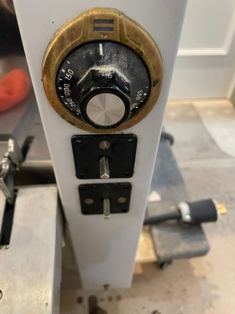 La Cornue brass bezel and control knob before deep cleaning and luxury detailing service.