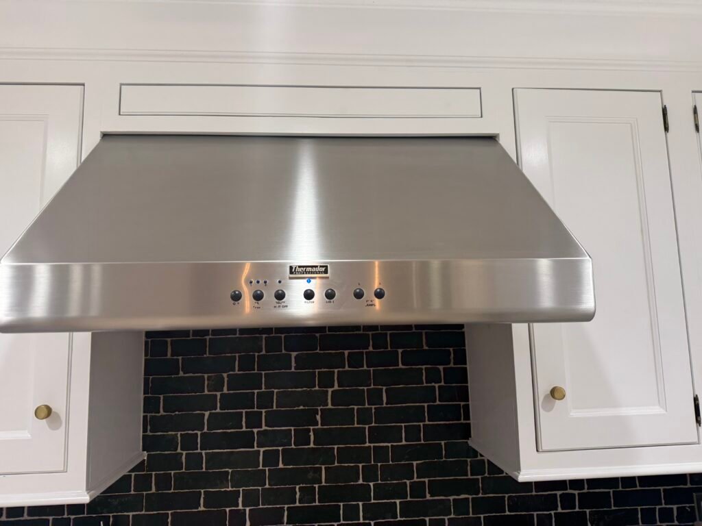 Expert polishing of stainless steel canopy and filters during Thermador range hood deep cleaning