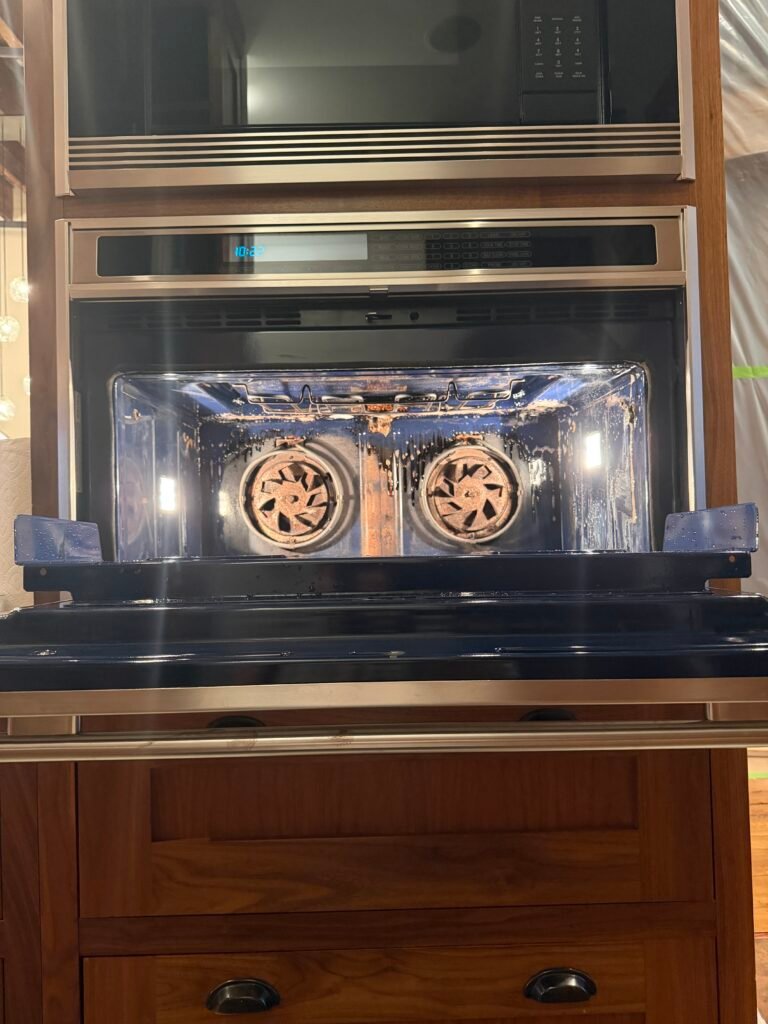 Built‑in electric Wolf oven before professional deep cleaning in NYC, showing grease and residue.