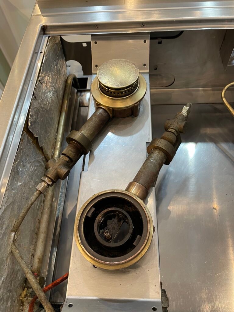 La Cornue ultra-high end cooking range brass burners, rings, and caps after professional restoration and detailing — spotless shine and renewed finish.