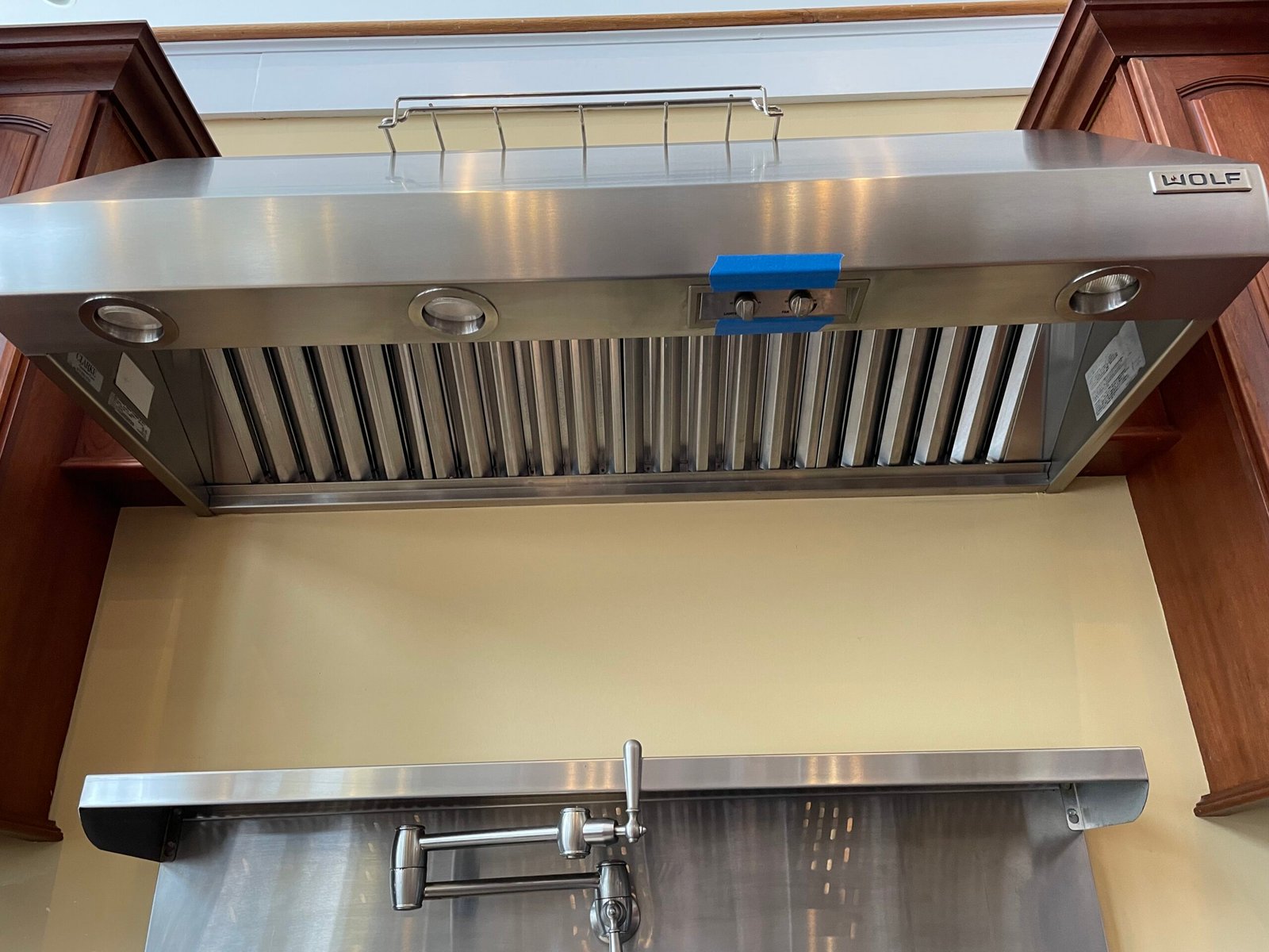 Professional degreasing of a luxury Wolf range hood in a New York City kitchen; filters and interior surfaces restored to peak ventilation efficiency by OvenPal NYC