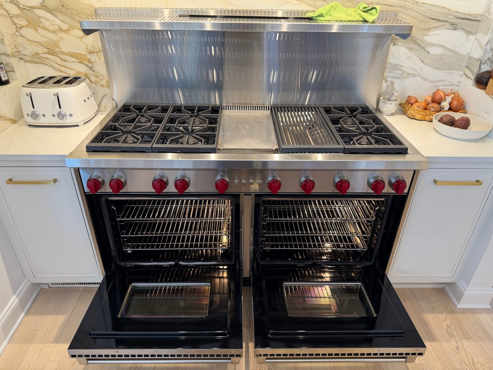 Deep cleaned Wolf double-oven gas range in a Manhattan kitchen with six burners and polished stainless-steel surfaces.